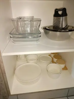 a shelf with plates and bowls and a blender at MamelaniQhibi Luxary Apartment in Nelspruit