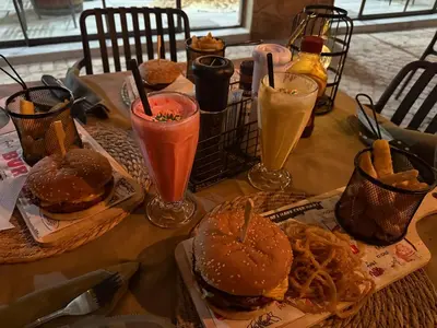 a table topped with sandwiches and drinks and onion rings at Moyo Safari Lodge in Alldays