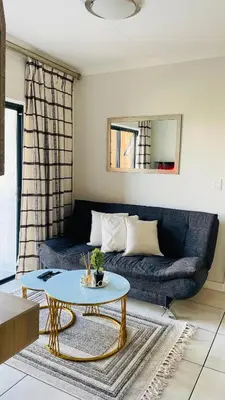 a living room with a couch and a table at Cozy abode in Pretoria