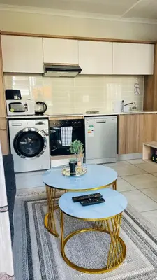 a kitchen with two tables and a stove at Cozy abode in Pretoria