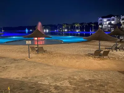 a swimming pool at night with chairs and umbrellas at Cozy abode in Pretoria