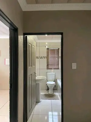 a bathroom with a white toilet and a sink at The Hope Apartments in Nelspruit