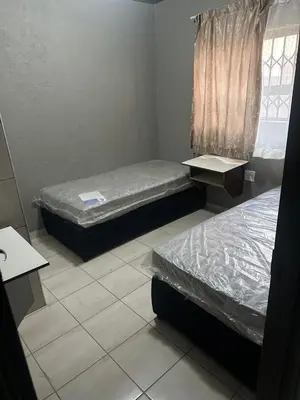 a room with two beds and a window at The Hope Apartments in Nelspruit