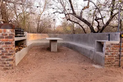 a concrete bench in front of a brick wall at Farmco Marloth Park in Marloth Park