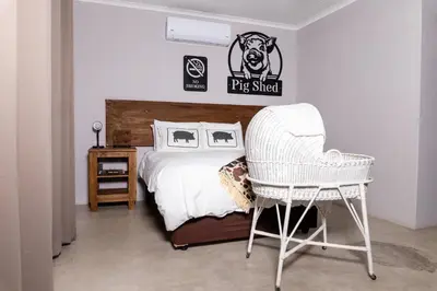 a bedroom with a bed and a chair at Farmco Marloth Park in Marloth Park