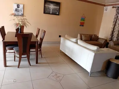 a living room with a couch and a table at M Palace Guest House in Kempton Park