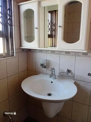 a bathroom with a white sink and a mirror at M Palace Guest House in Kempton Park