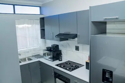 a white kitchen with a stove and a refrigerator at Springs Sleeper's Delight in Springs