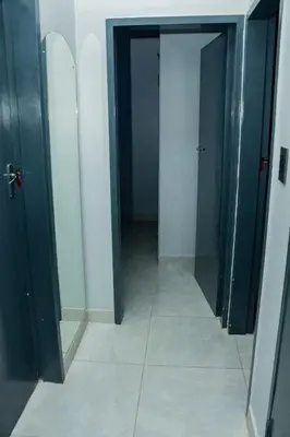 a hallway with two black doors and a tile floor at Springs Sleeper's Delight in Springs