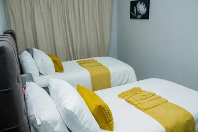 two beds in a room with yellow and white at Springs Sleeper's Delight in Springs