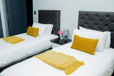 two beds with yellow pillows in a bedroom at Springs Sleeper's Delight in Springs