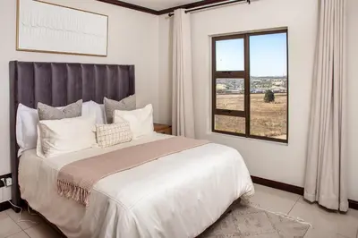a bedroom with a large bed and a window at Ever After Stays in Midrand