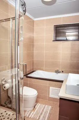 a bathroom with a toilet and a tub and a sink at Ever After Stays in Midrand