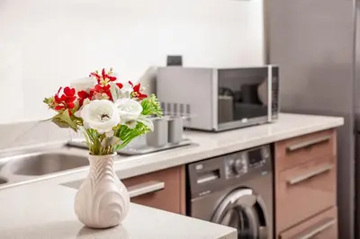 a white vase filled with flowers on a kitchen counter at Ever After Stays in Midrand