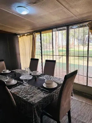 a dining room table with chairs and a tableclotholitics at Bird & Bed Farmhouse in Brits