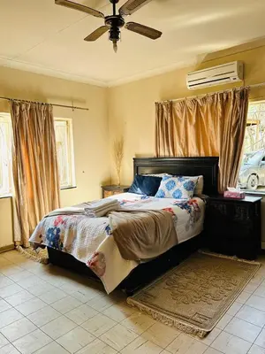 a bedroom with a bed and a ceiling fan at Bird & Bed Farmhouse in Brits