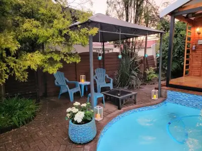 a patio with a table and chairs next to a pool at African Diamond - Date Night Suite in Benoni