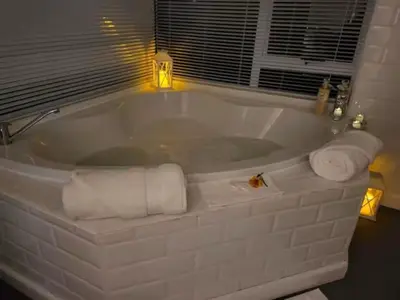 a white bath tub with towels in a bathroom at African Diamond - Date Night Suite in Benoni