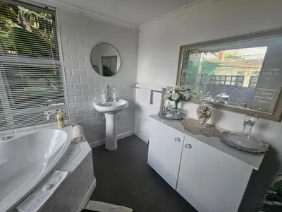 a white bathroom with a tub and a sink at African Diamond - Date Night Suite in Benoni