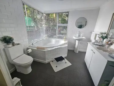 a bathroom with a tub and a toilet and a sink at African Diamond - Date Night Suite in Benoni