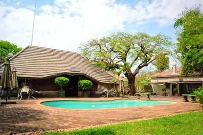 a house with a swimming pool in the yard at Sundown Lodge in Komatipoort