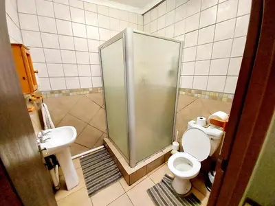 a bathroom with a shower and a toilet and a sink at Sundown Lodge in Komatipoort