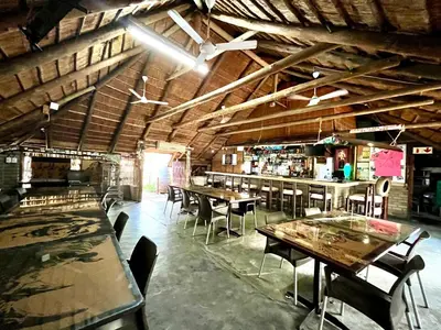 a restaurant with tables and chairs in a room at Sundown Lodge in Komatipoort