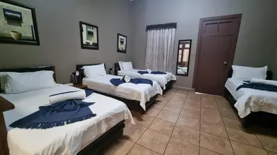 a room with three beds in a room at Sundown Lodge in Komatipoort