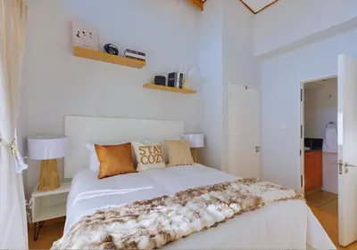 a white bedroom with a white bed with pillows at Carlswald Luxe in Midrand
