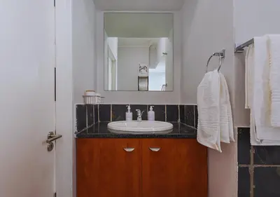 a bathroom with a sink and a mirror at Carlswald Luxe in Midrand