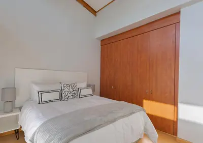 a bedroom with a large bed and a wooden cabinet at Carlswald Luxe in Midrand