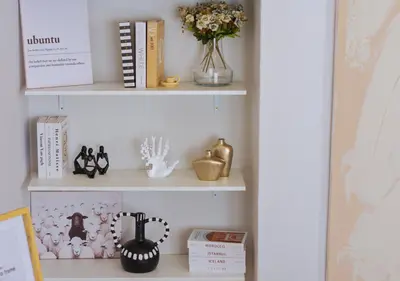 a shelf with books and other items on it at Carlswald Luxe in Midrand