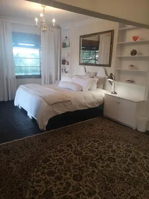 a bedroom with a large bed with white pillows at Lethabo Estate in Lanseria