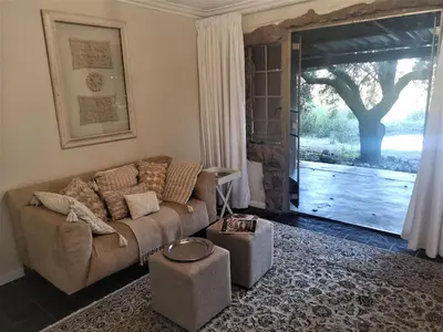 a living room with a couch and a sliding glass door at Lethabo Estate in Lanseria