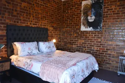 a bedroom with a bed in a brick wall at Dullight Self Cater Cottage in Dullstroom