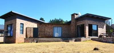 a brick house with a roof at Dullight Self Cater Cottage in Dullstroom