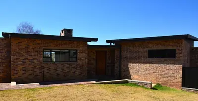 a brick house with a door and a yard at Dullight Self Cater Cottage in Dullstroom