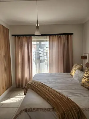 a bedroom with two beds and a window at Luxury Apartment - The Blyde Crystal Lagoon in Pretoria