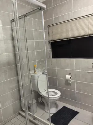 a bathroom with a toilet in a shower stall at Luxury Apartment - The Blyde Crystal Lagoon in Pretoria