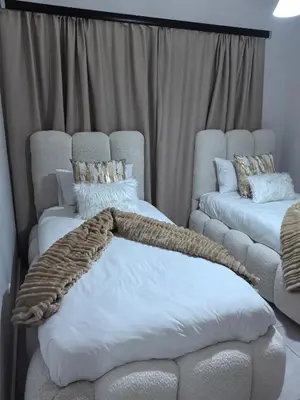 a bedroom with two beds and a couch and curtains at Luxury Apartment - The Blyde Crystal Lagoon in Pretoria