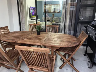 a wooden dining room table with chairs and a keyboard at Luxury Apartment - The Blyde Crystal Lagoon in Pretoria
