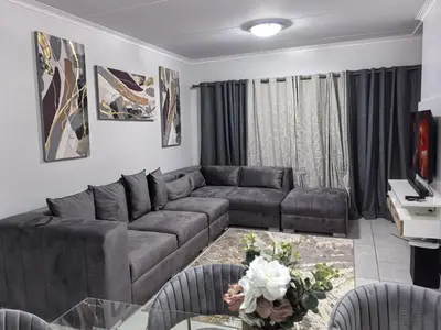a living room with a couch and a table at Luxury Apartment - The Blyde Crystal Lagoon in Pretoria
