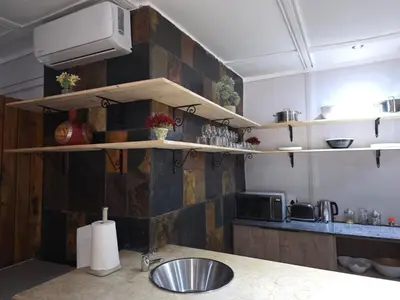 a kitchen with a counter with a sink and shelves at Nandoni Maritime Home in Thohoyandou