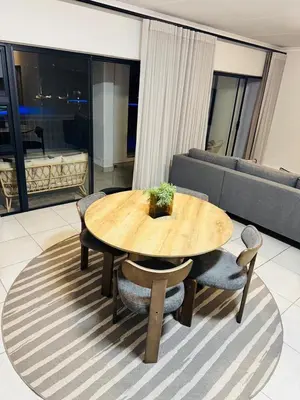 a wooden table and chairs in a living room at The Corinthians Lagoon facing in Pretoria