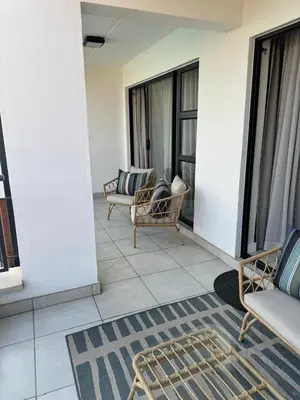a balcony with two chairs and a couch on a building at The Corinthians Lagoon facing in Pretoria