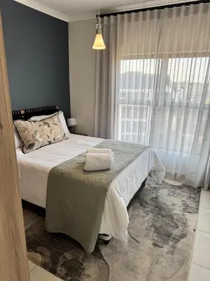 a bedroom with a bed and a large window at The Corinthians Lagoon facing in Pretoria