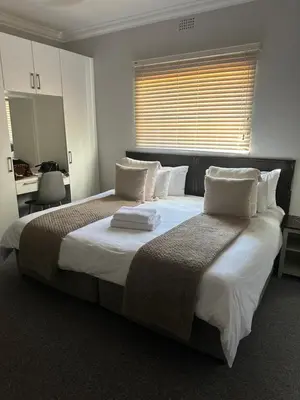 a bedroom with a large bed with white sheets and pillows at Valyspruit Trout Fishing and Game Retreat in Dullstroom