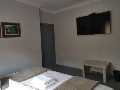 a bedroom with a bed and a flat screen tv at Valyspruit Trout Fishing and Game Retreat in Dullstroom