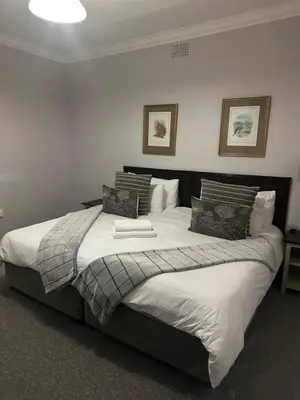 a bedroom with a large bed with white sheets and pillows at Valyspruit Trout Fishing and Game Retreat in Dullstroom