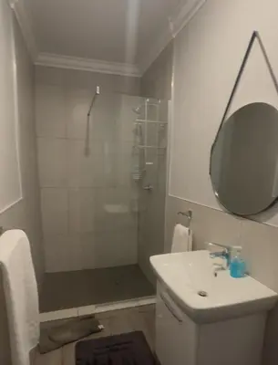 a bathroom with a shower and a sink and a mirror at Valyspruit Trout Fishing and Game Retreat in Dullstroom